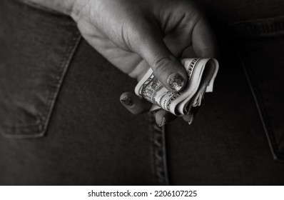 Woman Hand Taking Money From Jeans Back Pocket. Woman Hiding Money Behind Her Back. Dollar Banknotes Close Up