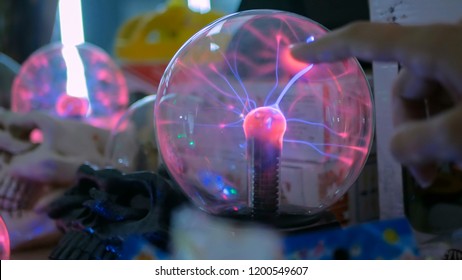 Woman Hand Touching Plasma Ball At Technology Exhibition. Physics Concept