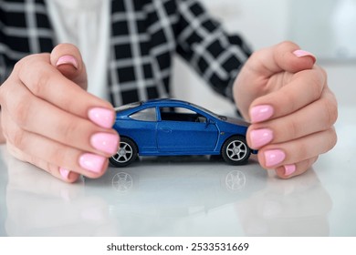 Woman hand with toy car as protective, insurance concept. Support - Powered by Shutterstock