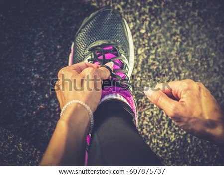 Woman hand tying shoes 