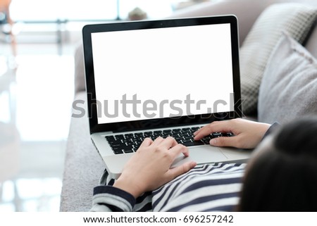 Woman hand typing labtop computer with blank screen for mock up, technology and lifestyle concept