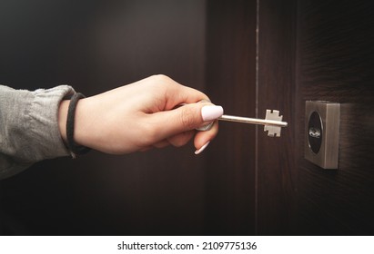 Woman Hand Unlocking Door With Key.