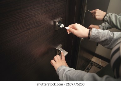 Woman Hand Unlocking Door With Key.