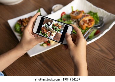 The woman hand is using a mobile phone to take a picture of food on the dining table in the restaurant.  Photography with Mobile Phone Concepts - Powered by Shutterstock