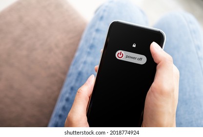 Woman Hand Using Is Sliding To Turn Off The Mobile Phone To Reduce Power Consumption. Technology And Environment Concept 