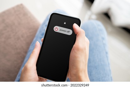 Woman Hand Using Is Sliding To Turn Off The Mobile Phone To Reduce Power Consumption. Technology And Environment Concept 