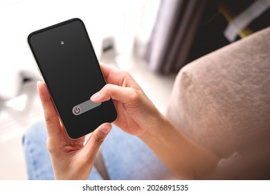 Woman Hand Using Is Sliding To Turn Off The Mobile Phone To Reduce Power Consumption. Technology And Environment Concept 