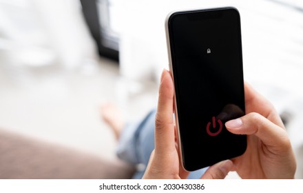 Woman Hand Using Is Sliding To Turn Off The Mobile Phone To Reduce Power Consumption. Technology And Environment Concept 