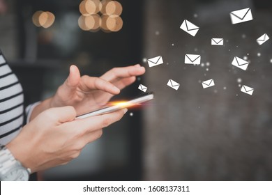 Woman hand using smart phone at coffee shop with email icon flying abstract. Technology business and freelance concept. Vintage tone filter effect color style.