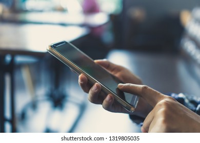 Woman hand using smartphone in cafe shop background. Business, financial, trade stock maket and social network concept. - Shutterstock ID 1319805035