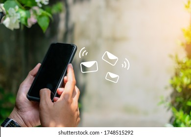 Woman Hand Using Smartphone And It's Show Email Recieve Notification Icon Pop Up On Screen Of Mobile Phone. Business Communication  Technology Concept.