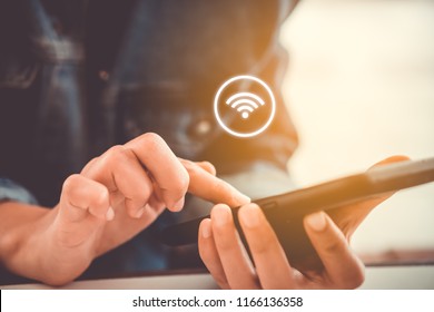 Woman hand using smartphone with wifi icon in cafe shop background. Business communication social network concept. - Shutterstock ID 1166136358