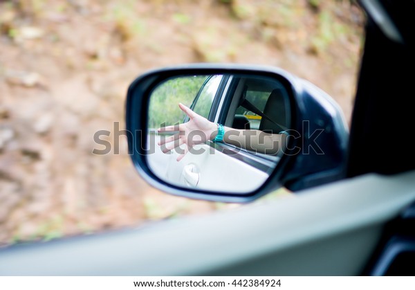 Woman hand in the\
view mirror (focus\
mirror).
