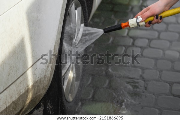 Woman hand washing car\
vehicle. Car washing service background. High pressure car cleaning\
tool. 