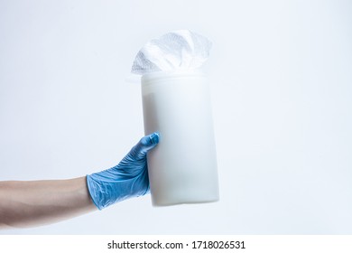 Woman Hand Wearing Protective Surgical Gloves Holds Plastic Dispenser Of Wet Disinfectant Bleach Wipes. Products That Kill Germs And Viruses 