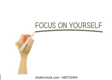 Woman hand writing FOCUS ON YOURSELF message on a transparent wipe board.