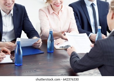 Woman Handing In Her Resume To Examination Board Member