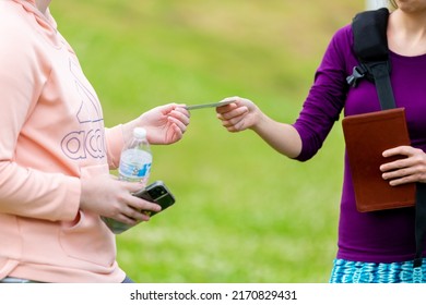 Woman Handing Tract To Another Woman