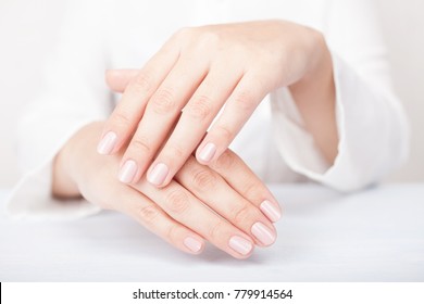 woman hands applying moisturizing cream to her skin - Shutterstock ID 779914564