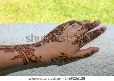 Woman Hands with black mehndi tattoo. Hands of Indian girl with black henna tattoos India