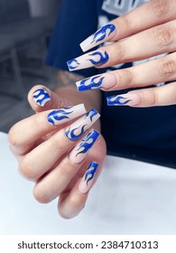 Mujer con diseño de uñas de fuego azul. Manicura. Salón de uñas. Clásico diseño de clavos de novia. Nails franceses