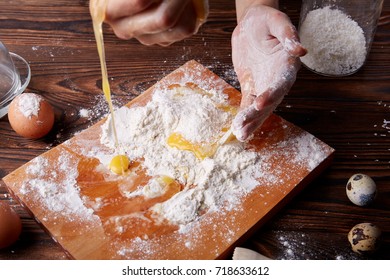 Woman hands breaking an egg to separate egg white and yolks and egg shells for preparing a pastry test at the background. - Shutterstock ID 718633612