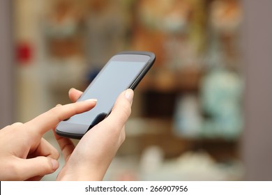 Woman Hands Buying Online With A Smart Phone In The Street In Front A Store