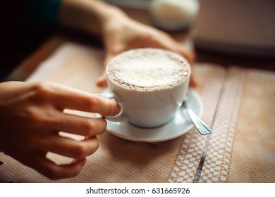 woman hands with cappuccino on a table