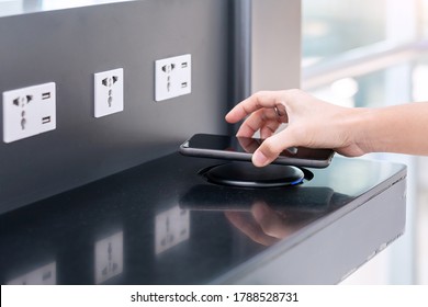 Woman hands charging battery in mobile smart phone by wireless charger at international airport terminal. Technology, multiple sharing and lifestyle concepts