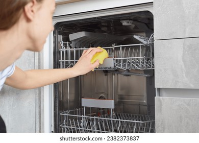 Woman hands cleaning dishwasher panel with yellow rag in kitchen. Close up. - Powered by Shutterstock