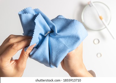 Woman Hands Cleaning And Polishing Golden Jewelry At Home. Top View