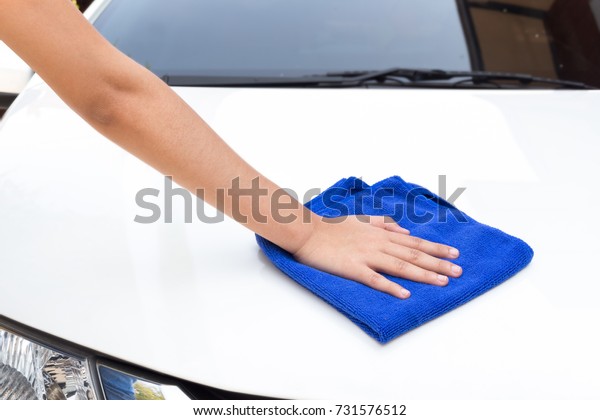 Woman\
hands cleaning white car using microfiber\
cloth
