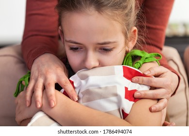 Woman Hands Conforting Troubled And Sad Teenager Girl - Holding Her By The Shoulders Leaning Over From Behind The Couch She Sits On, Close Up