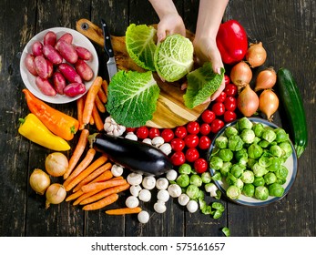 Woman Hands Cooking Vegetables On Dark Wooden Board. Healthy Eating And Vegetarian Concept. Top View