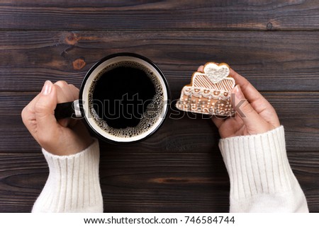 woman hands with cup of coffee with cookies.