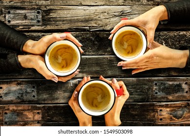 Woman hands with cup of hot fresh coffee. Free place for your text or products. Wooden old dirty table with shadows.Top view, flat photo, copy space. Winter time and hot drink in cup.Wooden old board