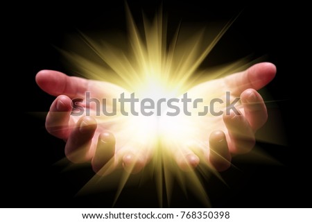 Woman hands cupped holding, showing, or emanating bright, glowing, radiant, shining light. Emitting rays or beams expanding. Religion, divine, heavenly, celestial concept. Black background, front view