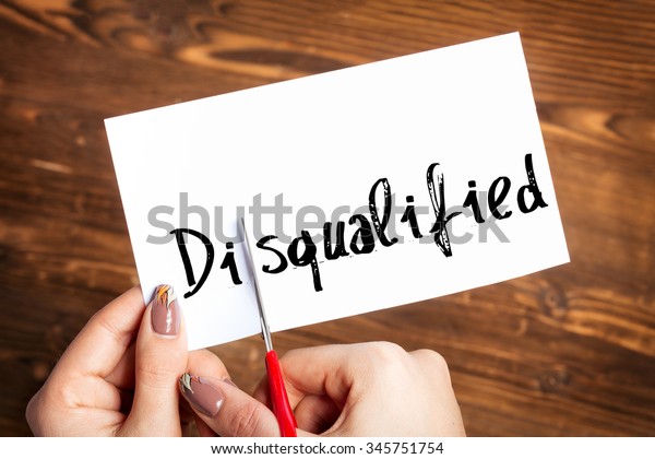 Woman hands\
cutting card with the word\
disqualified