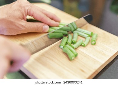 Woman hands cutting fresh green beans in a kitchen. Preparing of whole raw green vegetables. Green beans on a cutting board. Vegetarian healthy food. Product of organic farming. - Powered by Shutterstock