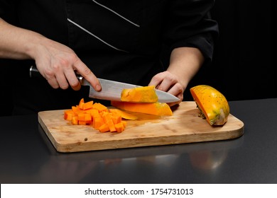 Woman Hands Cutting Papaya On A Wood Cut Board With A Knife