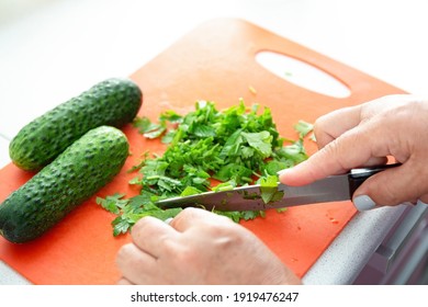 Woman hands cutting parsley on plastic board. Kitchen interier - Powered by Shutterstock