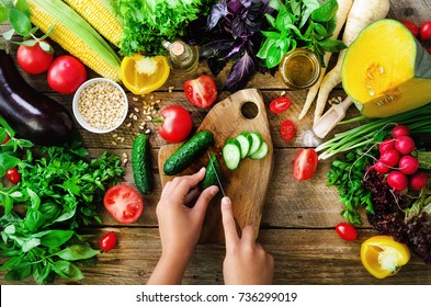 Woman hands cutting vegetables on wooden background. Cooking ingredients, top view, copy space, flat lay - Powered by Shutterstock