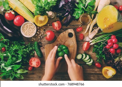 Woman hands cutting vegetables on wooden background. Vegetables cooking ingredients, top view, copy space, flat lay