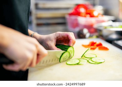 woman hands in disposable gloves slicing cucumber on cutting board. - Powered by Shutterstock