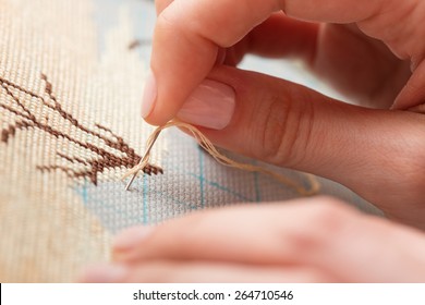 Woman Hands Doing Cross-stitch. A Close Up Of Embroidery.