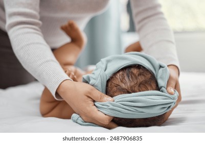 Woman, hands and dressing baby in clothes in home for morning, care and support for newborn. Mom, child and together in bedroom for love, helping and parent with routine for growth and development - Powered by Shutterstock