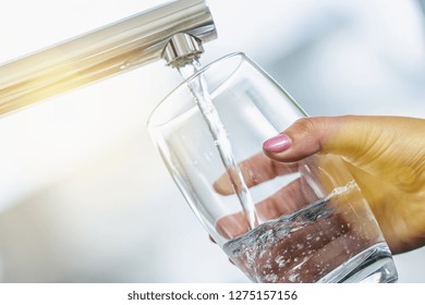 Woman Hand's Filling The Glass Of Water.