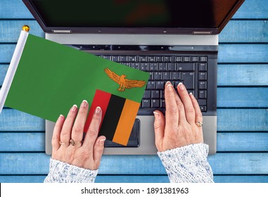 Woman Hands And Flag Of Zambia On Computer, Laptop Keyboard 