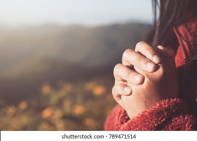 Woman hands folded in prayer in beautiful nature background with sunlight in vintage color tone - Shutterstock ID 789471514