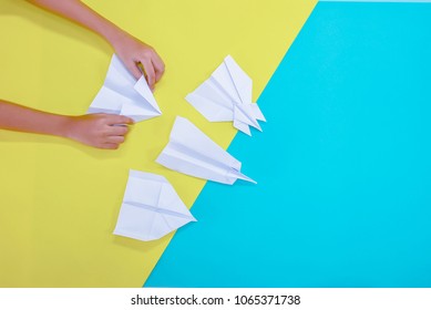 Woman Hands Folding Paper Desk Concept.Paper Folding Is A Plane.Development Of The Thinking System To Be A Step.There Are Several Planes.On A Yellow Background, Blue